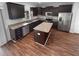 Kitchen with stainless steel appliances, dark cabinets, granite countertops, and an island at 10768 Carloway Hills Dr, Wimauma, FL 33598