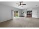 Spacious living room with a sliding glass door that leads to the backyard and an open view of the kitchen at 10768 Carloway Hills Dr, Wimauma, FL 33598