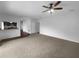 Open-concept living area features carpeted flooring and seamless transition to kitchen at 10768 Carloway Hills Dr, Wimauma, FL 33598