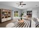 Bright living room boasts sliding glass doors, ceiling fan, and stylish black and white accents at 10768 Carloway Hills Dr, Wimauma, FL 33598