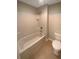 Bathroom showcasing a bright white tub and shower combination, along with a white toilet and tile flooring at 5383 Magdalene Way, Zephyrhills, FL 33541