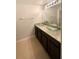 Bathroom featuring double bowl sinks with granite countertops and dark wood cabinetry at 5383 Magdalene Way, Zephyrhills, FL 33541