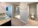 Bathroom featuring granite vanity with glass bowl sink, glass-enclosed shower, and separate toilet room at 5383 Magdalene Way, Zephyrhills, FL 33541
