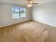 Bright bedroom with neutral walls and carpet, ceiling fan and natural light from the window at 5383 Magdalene Way, Zephyrhills, FL 33541