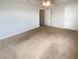 Bedroom featuring neutral walls and carpet, a ceiling fan and two doors, showcasing a clean and versatile space at 5383 Magdalene Way, Zephyrhills, FL 33541