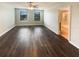 Large main bedroom featuring hardwood floors, ceiling fan and a view to an ensuite bathroom at 5383 Magdalene Way, Zephyrhills, FL 33541