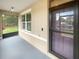 Covered entryway featuring a screened in patio, a window and a dark-colored front door with a screen at 5383 Magdalene Way, Zephyrhills, FL 33541