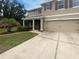 Two-story home featuring a two car garage, screened porch, and lush front yard at 5383 Magdalene Way, Zephyrhills, FL 33541