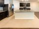 Modern kitchen island with stainless steel appliances, dark cabinets, and granite countertops at 5383 Magdalene Way, Zephyrhills, FL 33541