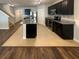 Modern kitchen with dark cabinets, stainless steel appliances, and a granite-topped island at 5383 Magdalene Way, Zephyrhills, FL 33541
