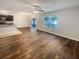 Bright living room with wood-look flooring, a ceiling fan, and sliding doors to the outdoor living area at 5383 Magdalene Way, Zephyrhills, FL 33541