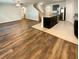 Spacious living room and kitchen area showcasing dark cabinets, island, and wood-look flooring at 5383 Magdalene Way, Zephyrhills, FL 33541