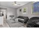 Cozy bonus room furnished with a gray sofa, beanbag chair, and a modern ceiling fan at 5651 Kelly N Dr, St Petersburg, FL 33703