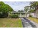 Single-story home featuring a well-maintained lawn, driveway, and lush landscaping at 5651 Kelly N Dr, St Petersburg, FL 33703
