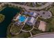 Aerial view of community pool, clubhouse, bocce ball court, lake, and walking trails at twilight at 2532 Avolet Ct, Lakewood Ranch, FL 34211