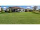 A spacious green backyard featuring a well-manicured lawn, patio, and lush, vibrant landscaping at 2532 Avolet Ct, Lakewood Ranch, FL 34211