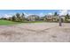 Community volleyball court with sand, net, poles, and green grass with houses and trees in the background at 2532 Avolet Ct, Lakewood Ranch, FL 34211