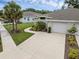 Lovely home features an attached garage, palm trees and fresh landscaping at 146 51St Street E Cir, Palmetto, FL 34221