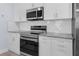 Modern kitchen featuring stainless steel appliances, granite countertops, and white subway tile backsplash at 146 51St Street E Cir, Palmetto, FL 34221