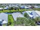 An aerial view showcasing pond-front homes surrounded by lush green landscaping and mature shade trees at 530 Bimini Bay Blvd, Apollo Beach, FL 33572