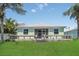 Rear view of home showing a wooden deck and patio, and expansive green lawn at 530 Bimini Bay Blvd, Apollo Beach, FL 33572