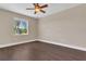 Bedroom with laminate floors and a window showcasing a palm tree view at 530 Bimini Bay Blvd, Apollo Beach, FL 33572