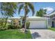 Charming, single-story home featuring lush landscaping, a palm tree, and a two-car garage at 530 Bimini Bay Blvd, Apollo Beach, FL 33572