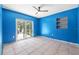 Bright blue bedroom with tile flooring and sliding glass door at 2302 16 W St, Palmetto, FL 34221
