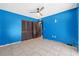 Blue bedroom featuring closet, tile floors, and ceiling fan at 2302 16 W St, Palmetto, FL 34221
