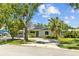 Inviting single-story home with a well-maintained front yard, mature trees, and solar panels at 2302 16 W St, Palmetto, FL 34221