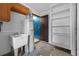Functional utility room featuring a sink, water heater, and built-in shelving for convenient storage at 2302 16 W St, Palmetto, FL 34221
