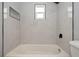 White bathroom featuring a tub with tiled surround and dark accents at 4651 Helena Ne St, St Petersburg, FL 33703