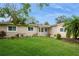 Inviting single-story home featuring a lush green lawn, manicured garden beds, and a delightful blue front door at 4651 Helena Ne St, St Petersburg, FL 33703