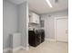 Updated laundry room with modern washer and dryer units and storage cabinets at 4651 Helena Ne St, St Petersburg, FL 33703