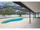 Inviting screened-in pool with light tile decking and room for entertaining, surrounded by lush greenery at 4651 Helena Ne St, St Petersburg, FL 33703