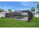 View from yard of screened pool area, with backyard and exterior of house in the background at 4651 Helena Ne St, St Petersburg, FL 33703