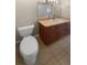 Bathroom with a toilet, tile flooring, and vanity with warm wood cabinets and a white sink at 915 Woodbridge Ct, Safety Harbor, FL 34695