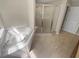 Bathroom featuring a soaking tub, glass shower, and tile floor at 915 Woodbridge Ct, Safety Harbor, FL 34695