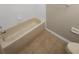 Clean bathroom featuring a tiled floor and a bathtub with white tile surround at 915 Woodbridge Ct, Safety Harbor, FL 34695