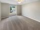 Bright bedroom with neutral tones, ceiling fan, and a large window offering neighborhood views at 915 Woodbridge Ct, Safety Harbor, FL 34695