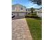 Charming townhome with a paver driveway, lush landscaping, and an attached one car garage at 915 Woodbridge Ct, Safety Harbor, FL 34695