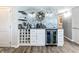 A bar area with wine storage, mini refrigerator, mosaic tile accent wall, and stylish decor at 14146 Gulf Blvd # 3A, Madeira Beach, FL 33708