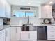 Bright kitchen featuring white cabinets, stainless steel appliances, granite counters, and a modern stainless steel sink at 14146 Gulf Blvd # 3A, Madeira Beach, FL 33708