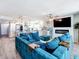 A cozy living room offers an open concept with modern kitchen, fireplace and a large blue velvet couch at 14146 Gulf Blvd # 3A, Madeira Beach, FL 33708