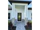 Close-up of a modern home's front door with stone accents and fresh landscaping at 1160 Edinburgh St, North Port, FL 34288