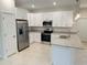 Well-lit kitchen featuring white cabinets, stainless steel appliances, and granite countertops at 1160 Edinburgh St, North Port, FL 34288
