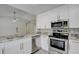 Modern kitchen with stainless steel appliances, white cabinetry, and stylish countertops, perfect for culinary enthusiasts at 9497 122Nd Way, Seminole, FL 33772