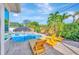 Inviting pool area featuring comfortable lounge chairs and a shaded tiki umbrella for relaxation and enjoyment at 9497 122Nd Way, Seminole, FL 33772
