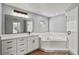Bright bathroom features white vanity with black hardware, walk-in shower, and soaking tub at 1438 Mclin Dr, Plant City, FL 33565