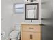 This light-filled bathroom features a modern vanity with wood grain, updated fixtures, and clean white walls at 1438 Mclin Dr, Plant City, FL 33565